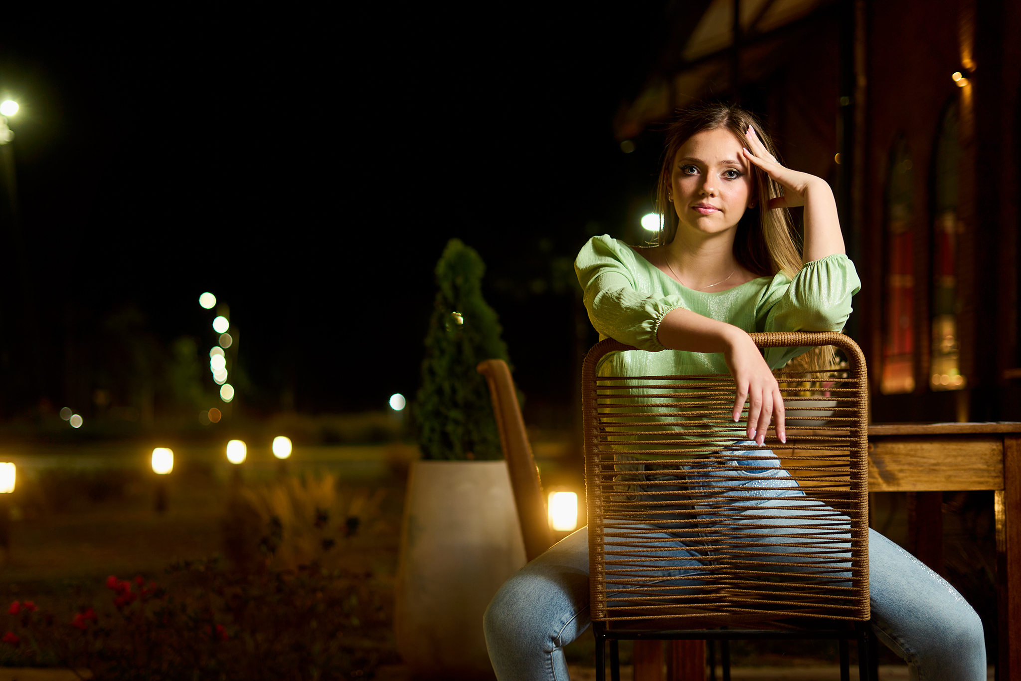 Retrato en una silla de mimbre, en el jardín iluminado de una quinta de noche. Sesión nocturna de DNX Estudio, San José 1672 Local 5, Funes.